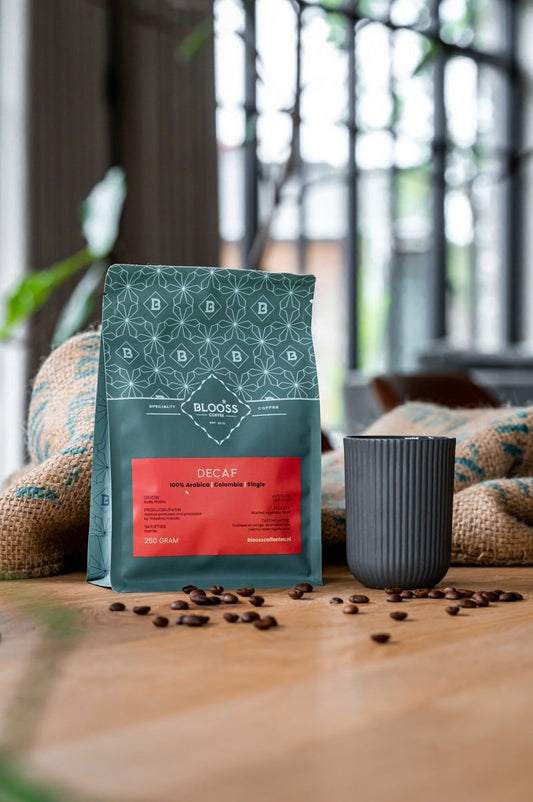 Decaf koffiebonen naast koffiekopje